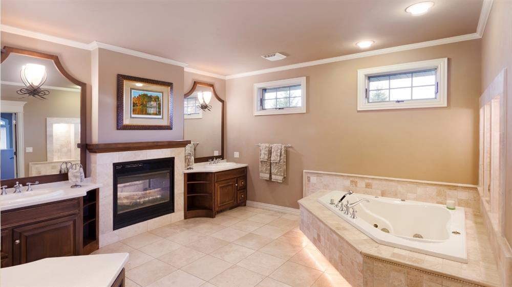 Elegant bathroom with whirlpool bathtub and wooden vanity